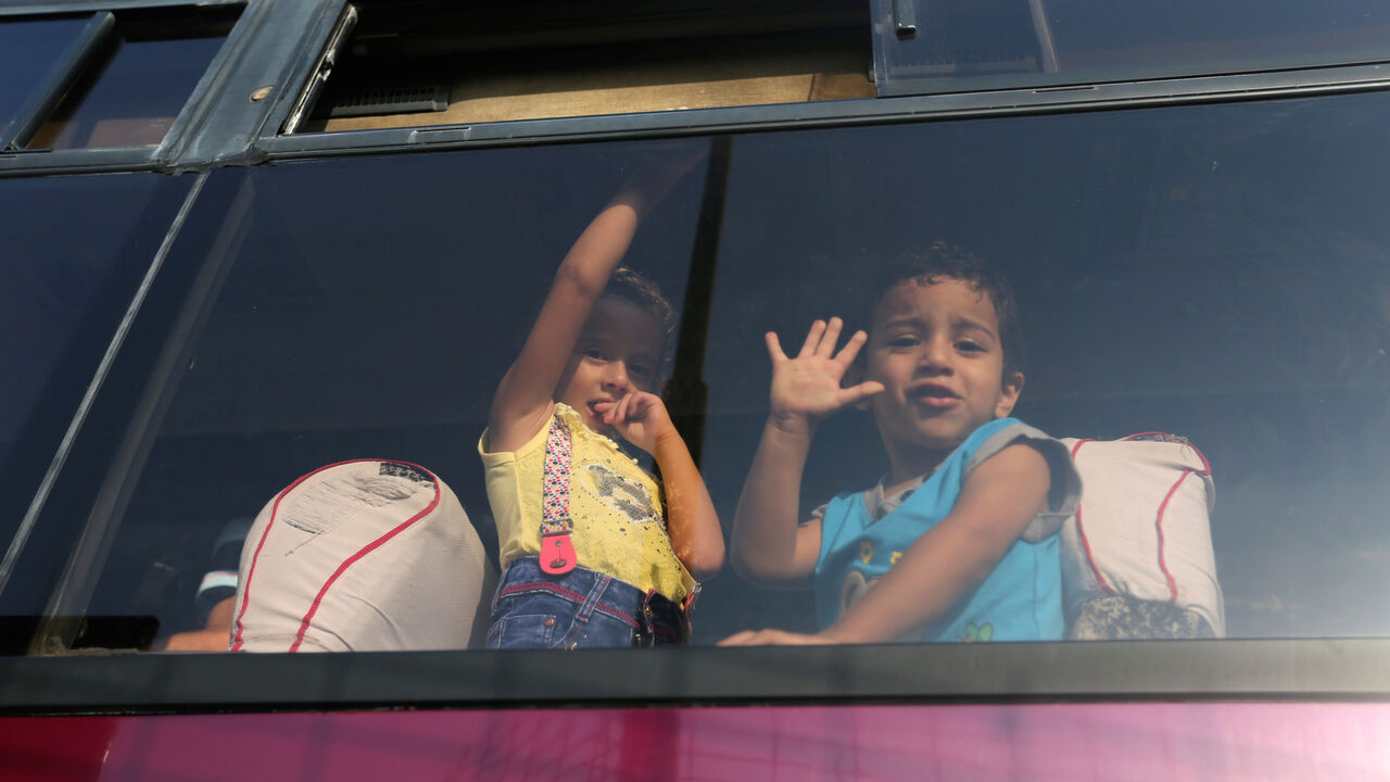 Palestinian children look out through a bus window as they wait with their family to cross into Egypt through the Rafah border crossing after it was opened by Egyptian authorities for humanitarian cases, in Rafah in the southern Gaza Strip August 27, 2017. REUTERS/Ibraheem Abu Mustafa - RC1E970E29C0