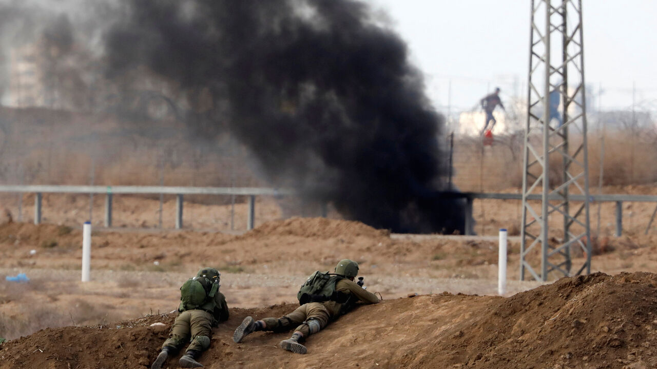 Israeli soldiers are seen at the Israeli side of the Israel Gaza border as Palestinians protest on Gaza side, December 15, 2017. REUTERS/Amir Cohen - RC17C07ADB10