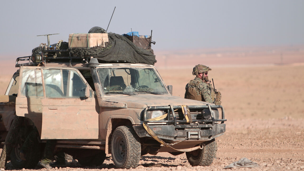 A U.S. fighter stands near a military vehicle, north of Raqqa city, Syria November 6, 2016. REUTERS/Rodi Said - S1AEULHHBDAA