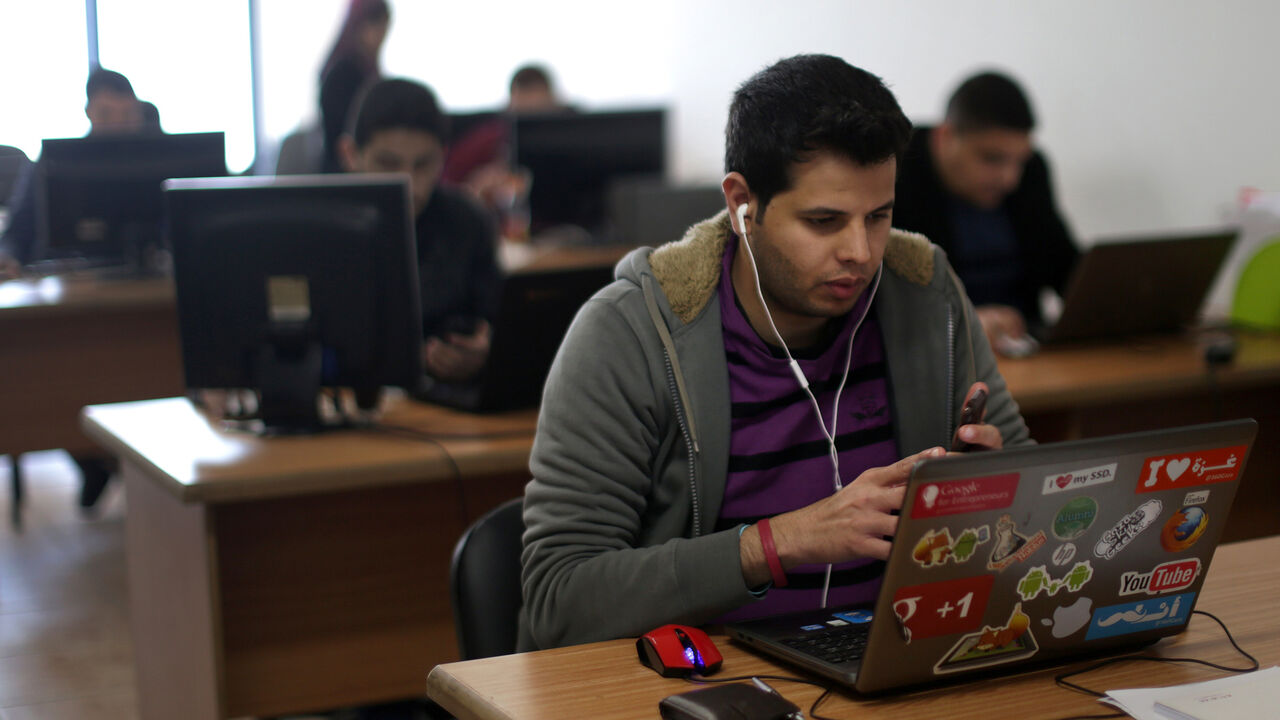 TO GO WITH AFP STORY BY SARAH BENHAIDA 
A Palestinian man works in front of a laptops at Unit One start up in Gaza City, on April 18, 2015. Israel controls all of Gaza's cable communications which are routed through the Jewish state, and also controls the bandwidth of its Internet lines, meaning that it has the technical ability to completely sever the territory's digital link to the rest of the world. In the perpetually-connected world of technology, having electricity is also crucial but far from certain 