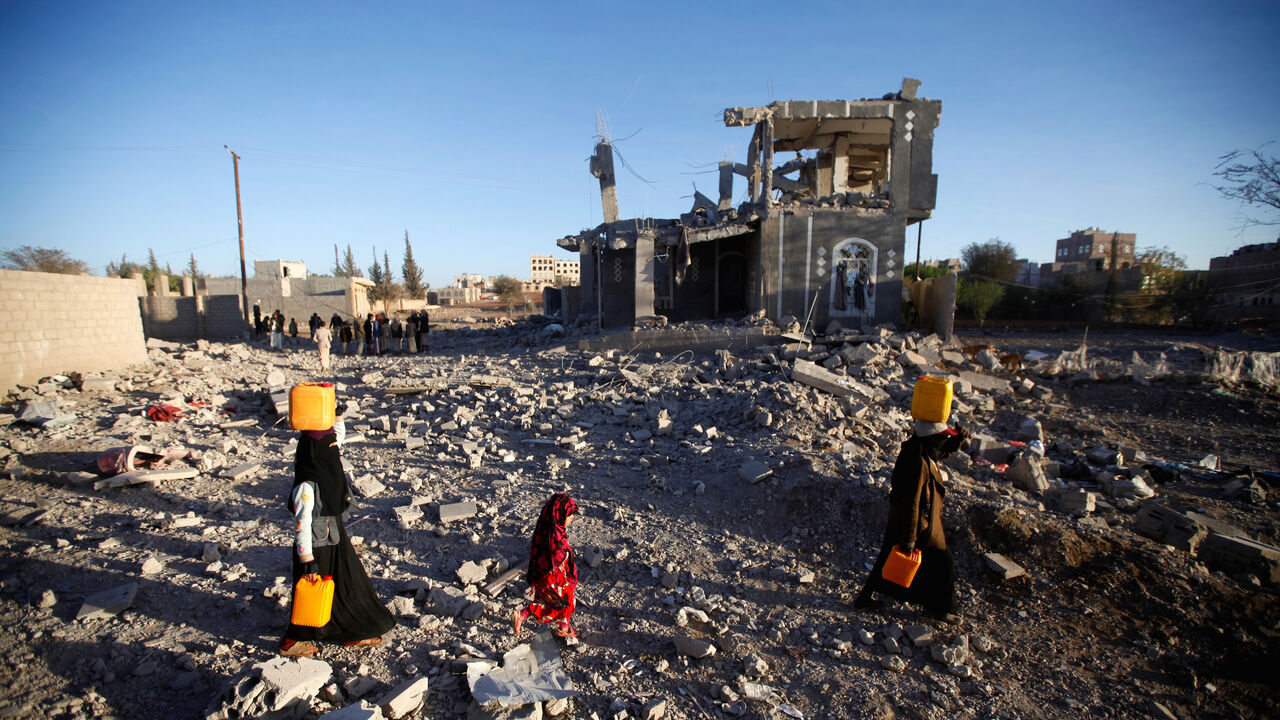 People carry water tanks as they walk at the site of damage after a Saudi-led air strike, north of Yemen’s capital Sanaa, March 8, 2018. REUTERS/Mohamed al-Sayaghi - RC1A64C77B50