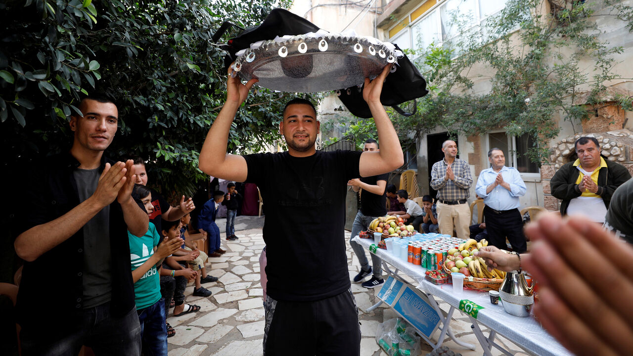 Palestinian groom Hejres Torokman carries his suit over his head as he prepares for his wedding party, in Jenin in the occupied West Bank May 7, 2018. Picture taken May 7, 2018. REUTERS/Mohamad Torokman - RC1A989FF9A0