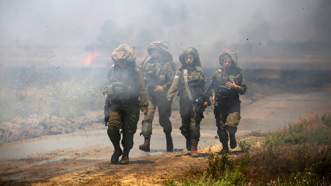 Israeli soldiers patrol near a burning field on the Israeli side of the border between Israel and Gaza, May 14, 2018. REUTERS/Amir Cohen     TPX IMAGES OF THE DAY - RC1FB2222060