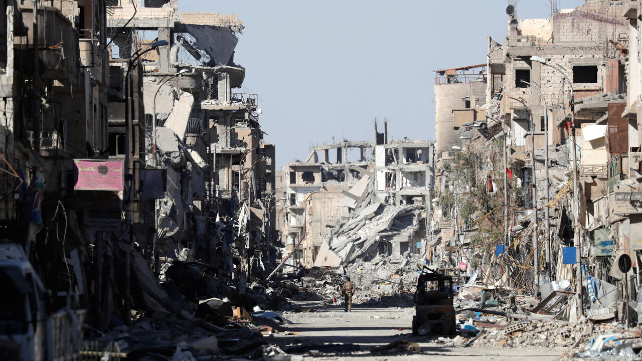 A fighter of Syrian Democratic Forces stands amidst the ruins of buildings near the Clock Square in Raqqa, Syria October 18, 2017. Picture taken October 18, 2017.     REUTERS/Erik De Castro - RC1E4E003870