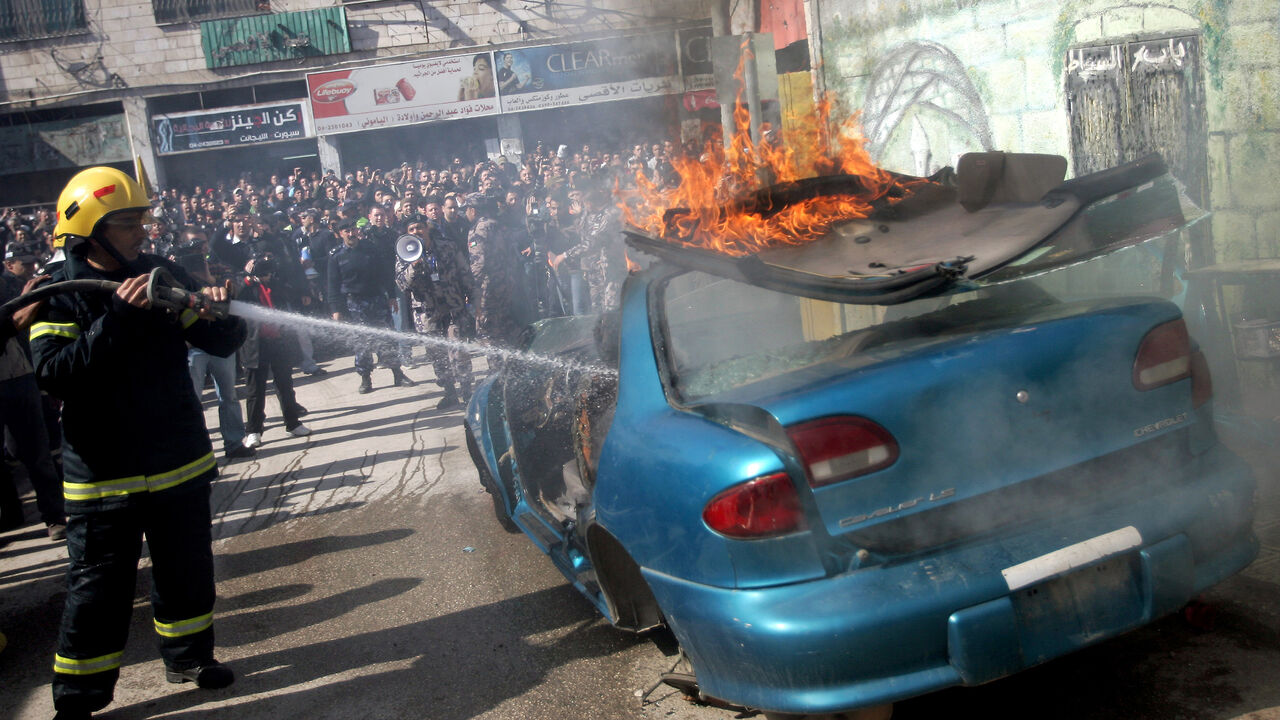 A Palestinian firefighter douses a burning car during an earthquake drill organised by the civil defence forces in the West Bank city of Jenin on February 16, 2012. AFP PHOTO/SAIF DAHLAH (Photo credit should read SAIF DAHLAH/AFP/Getty Images)