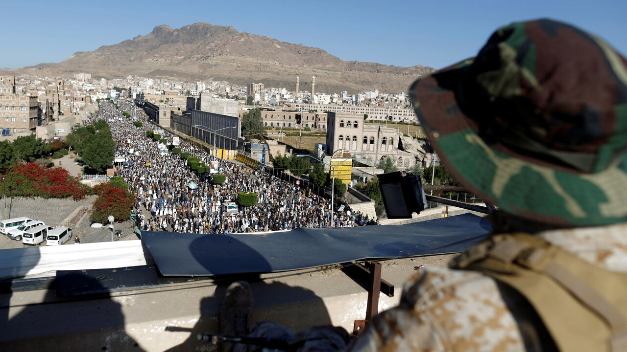 A Houthi militant sits guard on the roof of a building overlooking fellow Houthis rallying to denounce the rapid devaluation of the Yemeni Rial in Sanaa, Yemen October 5, 2018. REUTERS/Khaled Abdullah - RC149994CBB0