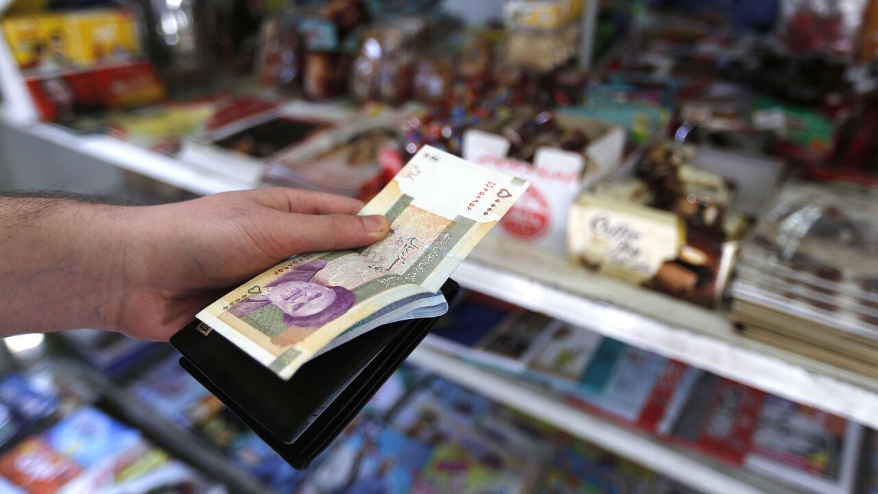 A man holds a stack of Iranian Rials in front of a shop in the capital Tehran on July 31, 2018. - Iran's currency traded at a fresh record-low of 119,000 to the dollar on today, a loss of nearly two-thirds of its value since the start of the year as US sanctions loom. (Photo by ATTA KENARE / AFP)        (Photo credit should read ATTA KENARE/AFP/Getty Images)