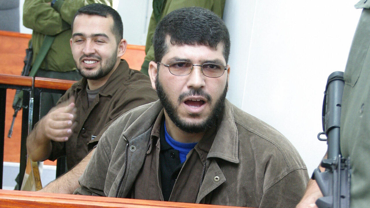 OFER CAMP, -:  Palestinians Mohammed Hassan Arman (R) and Walid Anjaf sit in the Ofer army base military court in the West Bank, north of Jerusalem, 30 November 2003 before being sentenced to 36 consecutive life sentences for masterminding suicide bombings at Jerusalem's Hebrew university, the Moment cafe and other attacks which left 36 Israelis dead.      AFP PHOTO/Brian HENDLER  (Photo credit should read BRIAN HENDLER/AFP/Getty Images)