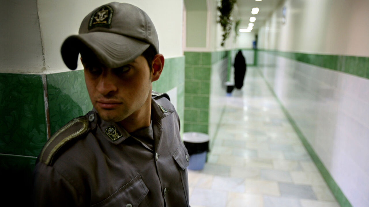 A prison guard stands along a corridor in Tehran's Evin prison June 13, 2006. Iranian police detained 70 people at a demonstration in favour of women's rights, the judiciary said on Tuesday, adding it was ready to review reports that the police had beaten some demonstrators. - PBEAHUNMBAM