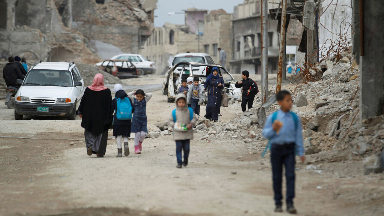 Iraqi school students pass by destroyed buildings by the war, in the Old City of Mosul, Iraq February 27, 2019. REUTERS/Khalid al-Mousily - RC1D1A58CF70
