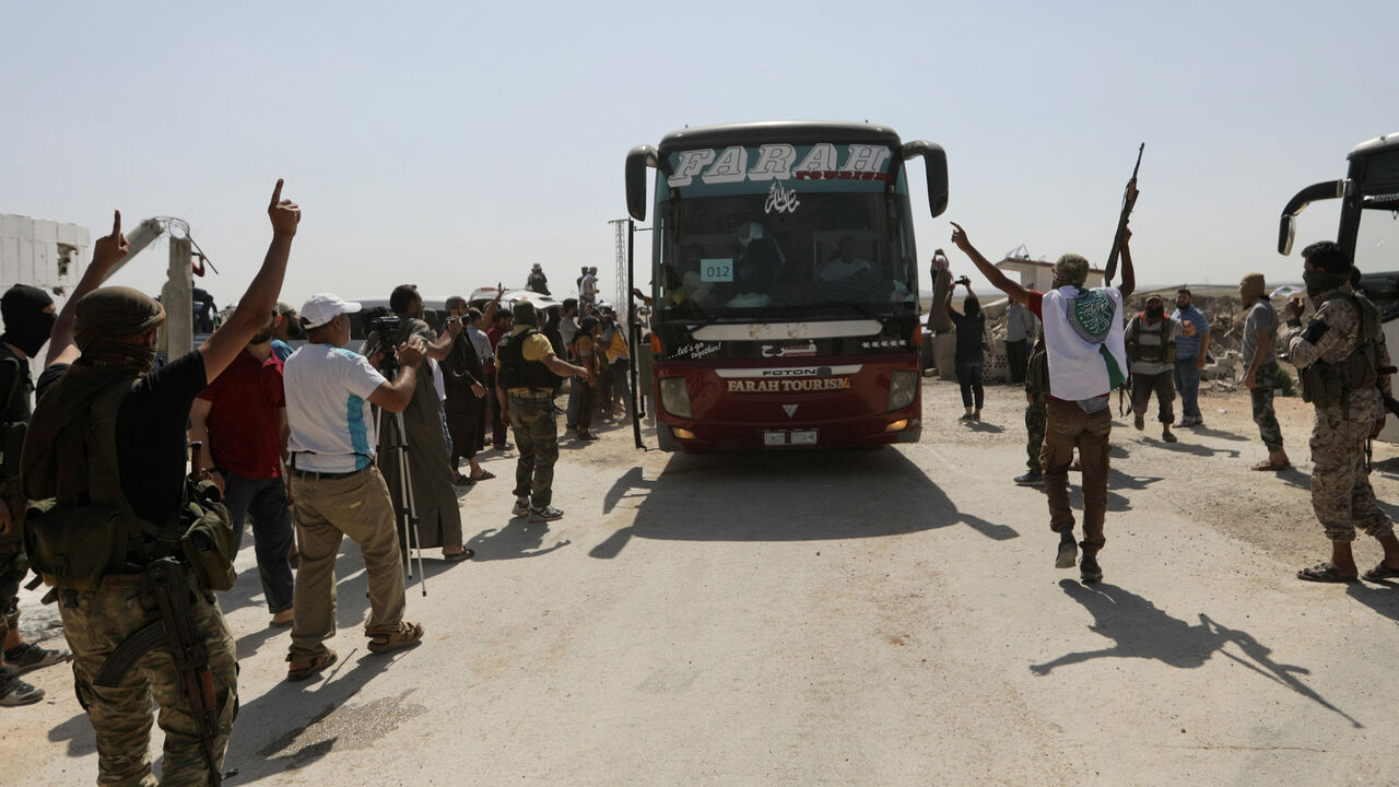 Islamist rebels from Hayat Tahrir al-Sham celebrate for their families and relatives who are released from government prisons, as they arrive to El Eis area in southern Aleppo, Syria July 19, 2018. REUTERS/Khalil Ashawi - RC1418535730