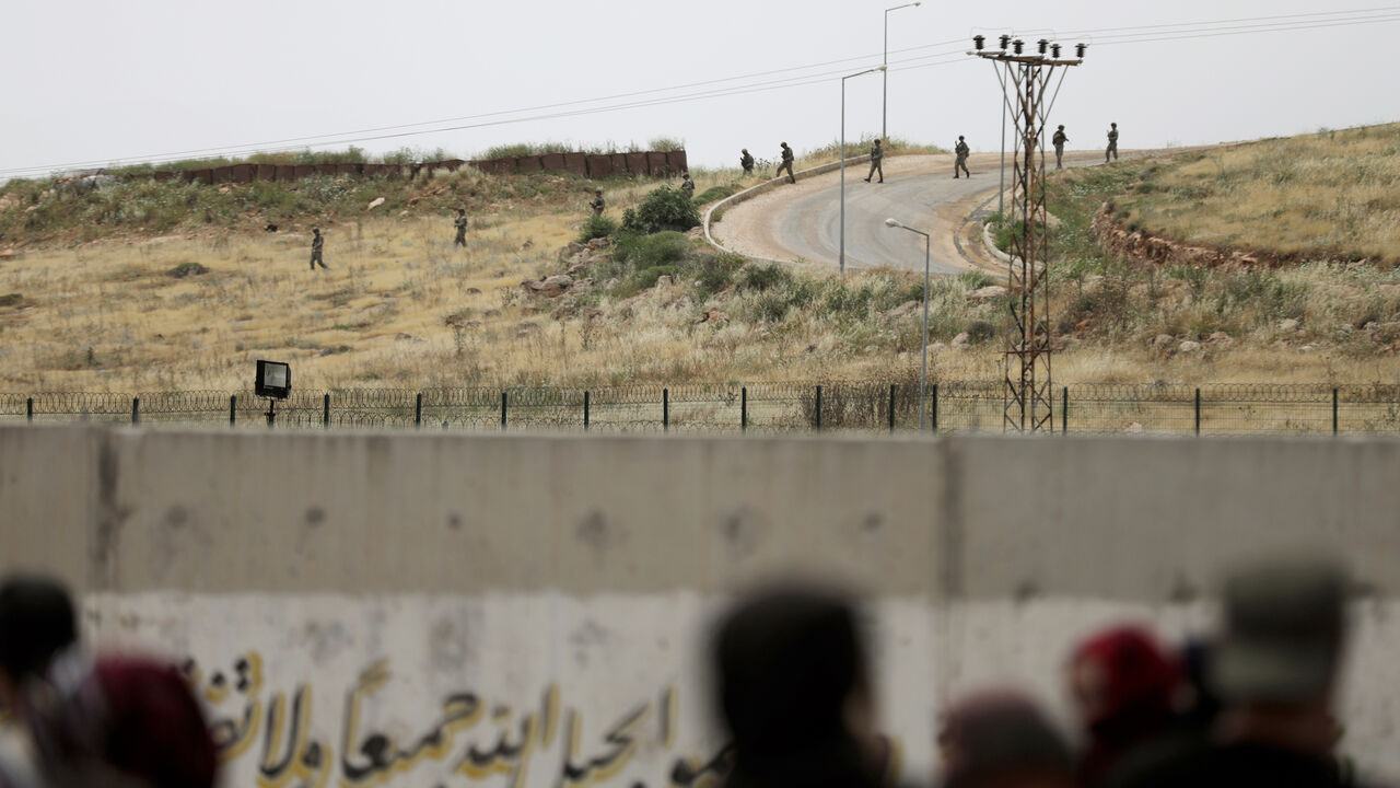 Turkish soldiers walk at the Atmeh crossing on the Syrian-Turkish border, as seen from the Syrian side, in Idlib governorate, Syria May 31, 2019. REUTERS/Khalil Ashawi - RC17B93A8C20