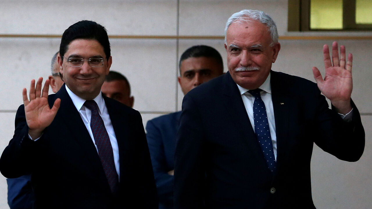 Moroccan Foreign Minister Nasser Bourita waves with Palestinian Foreign Minister Riyad Al Maliki upon his arrival in Ramallah, in the occupied West Bank March 27, 2018. REUTERS/Mohamad Torokman/Pool - RC1185BBFF50