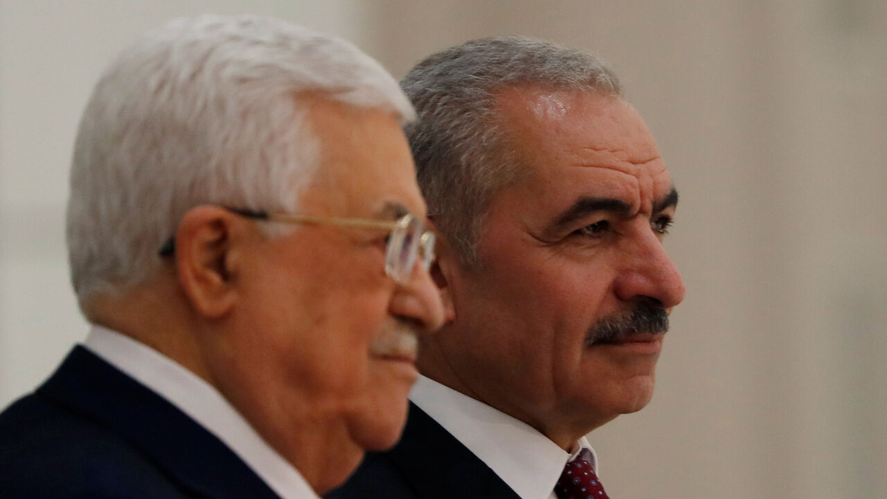 New Palestinian Prime Minister Mohammad Shtayyeh stands next to President Mahmoud Abbas during a swearing in ceremony of a new government, in Ramallah in the Israeli-occupied West Bank April 13, 2019. REUTERS/Mohamad Torokman - RC1F397216C0