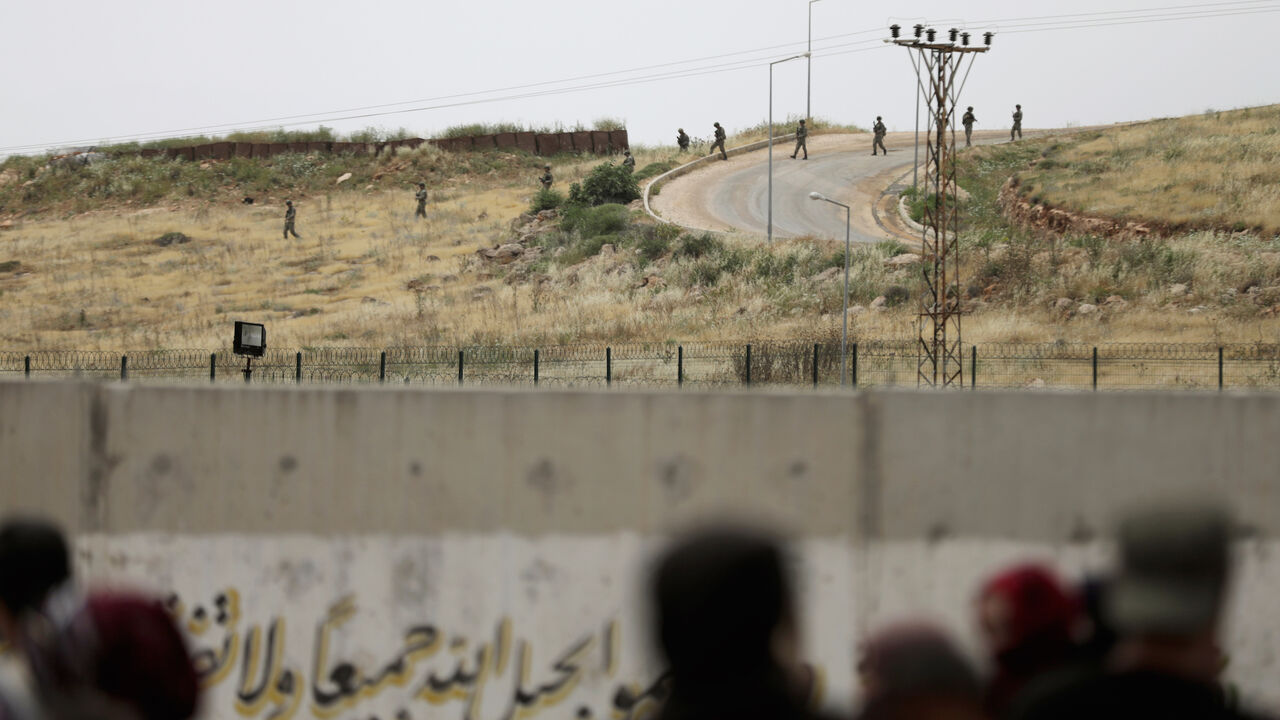 Turkish soldiers walk at the Atmeh crossing on the Syrian-Turkish border, as seen from the Syrian side, in Idlib governorate, Syria May 31, 2019. REUTERS/Khalil Ashawi - RC17B93A8C20