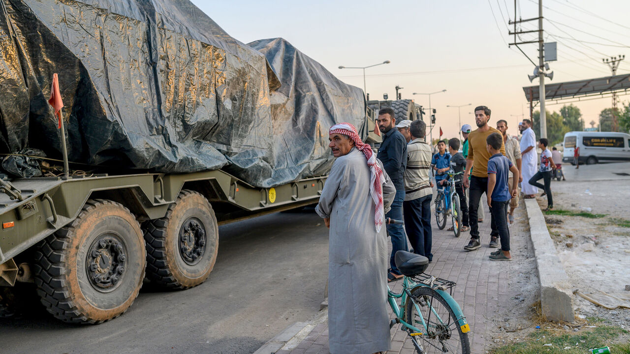 Turkish civilians look at a Turkish army's convoy driving towards the Syrian border near Akcakale in Sanliurfa province on October 9, 2019. - Turkey launched an assault on Kurdish forces in northern Syria on October 9 with air strikes and artillery fire reported along the border. The Turkish President announced the start of the attack on Twitter, labelling it "Operation Peace Spring". It triggered criticism from Western countries who have allied with the Kurdish-led Syrian Democratic Forces (SDF) against th