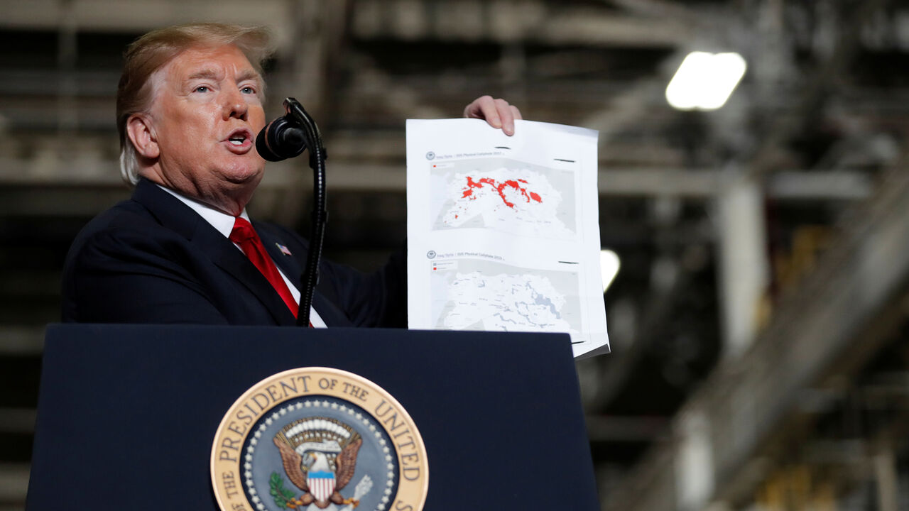 U.S. President Donald Trump shows maps of Syria and Iraq depicting the size of the "ISIS physical caliphate" as he speaks to workers while touring the Lima Army Tank Plant (LATP) Joint Systems Manufacturing Center, the country's only remaining tank manufacturing plant, in Lima, Ohio, U.S., March 20, 2019. REUTERS/Carlos Barria - RC139DF142F0