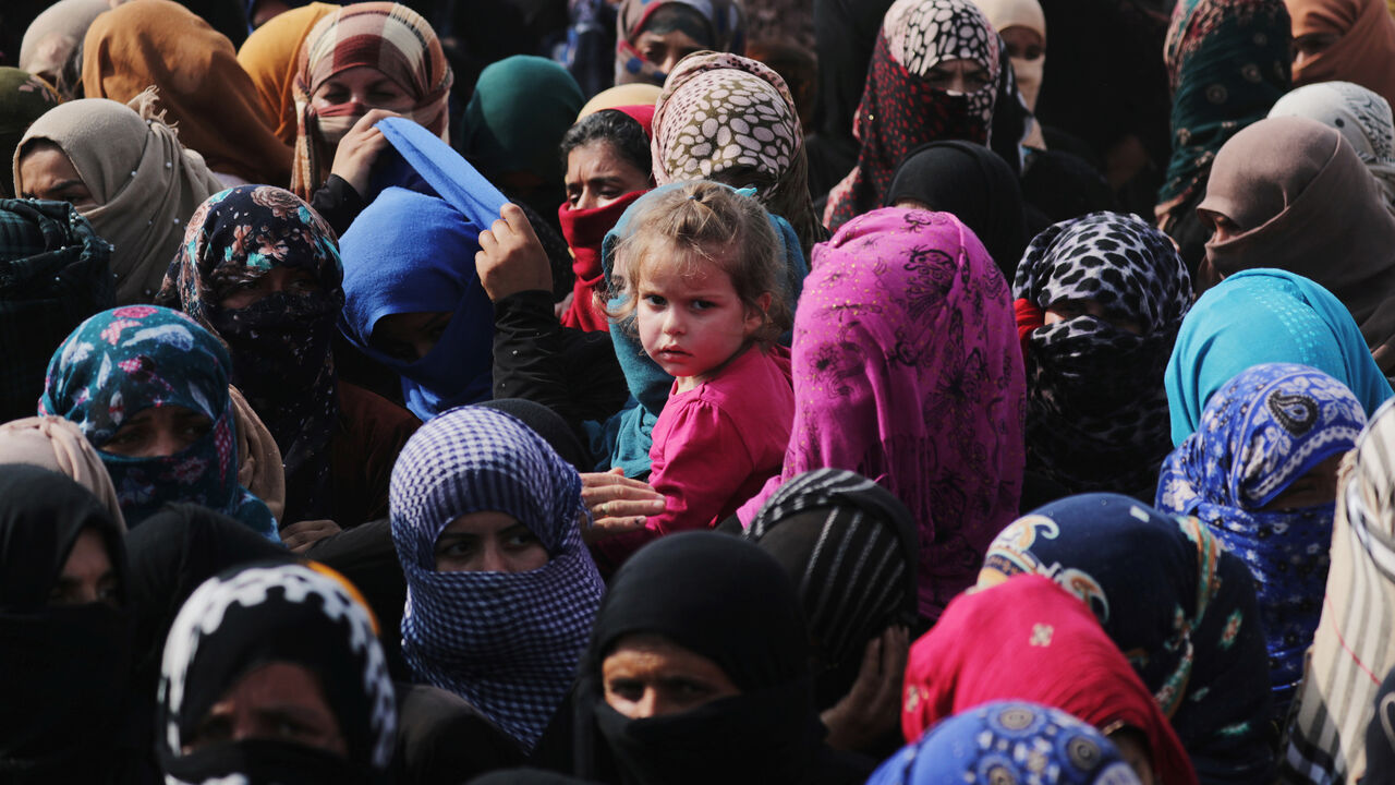 A child looks to the camera as people receive aid donated by the Turkish Red Crescent in the border town of Tal Abyad, Syria, October 19, 2019. REUTERS/Khalil Ashawi - RC121E51D730