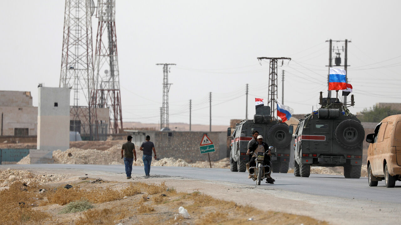 Russian and Syrian national flags flutter on military vehicles near Manbij, Syria October 15, 2019. REUTERS/Omar Sanadiki - RC1E8CFB81C0