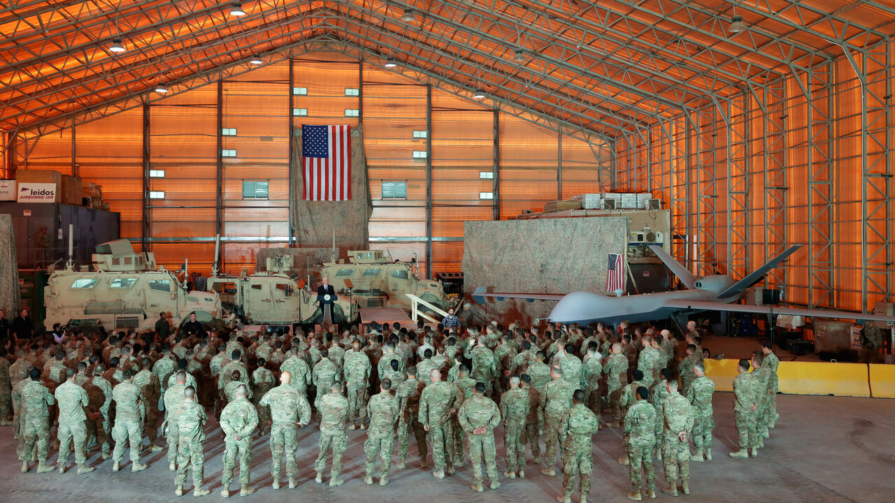 A drone and armored vehicles serve as a backdrop as U.S. Vice President Mike Pence delivers remarks to U.S. troops at Al Asad Air Base, Iraq November 23, 2019. REUTERS/Jonathan Ernst - RC29HD9HDU3K