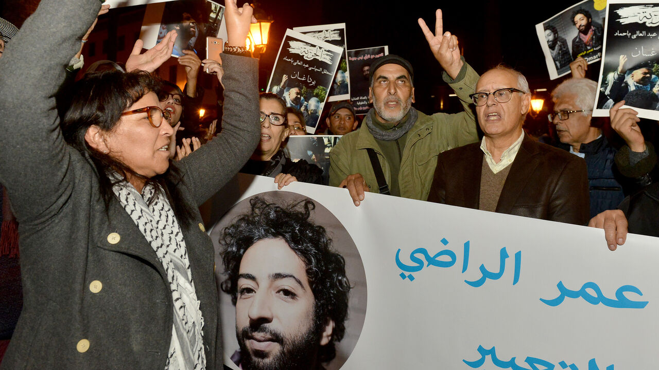 Demonstrators shoot slogans and hold a banner showing a portrait of Omar Radi, a Moroccan journalist detained over tweet criticising judge, during a demonstration, on December 28, 2019, in the city of Rabat. (Photo by STR / AFP) (Photo by STR/AFP via Getty Images)