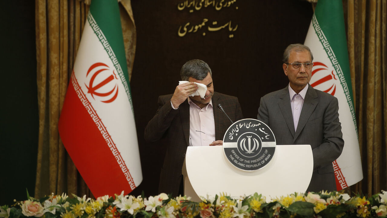 Iranian Deputy Health Minister Iraj Harirchi (L) wipes the sweat off his face, during a press conference with the Islamic republic's government spokesman Ali Rabiei in the capital Tehran on February 24, 2020. - Iran's deputy health minister confirmed on February 25, that he has tested positive for the novel coronavirus, amid a major outbreak in the Islamic republic. Harirchi coughed occasionally and appeared to be sweating during the press conference with Rabiei in Tehran. (Photo by Mehdi BOLOURIAN / FARS N