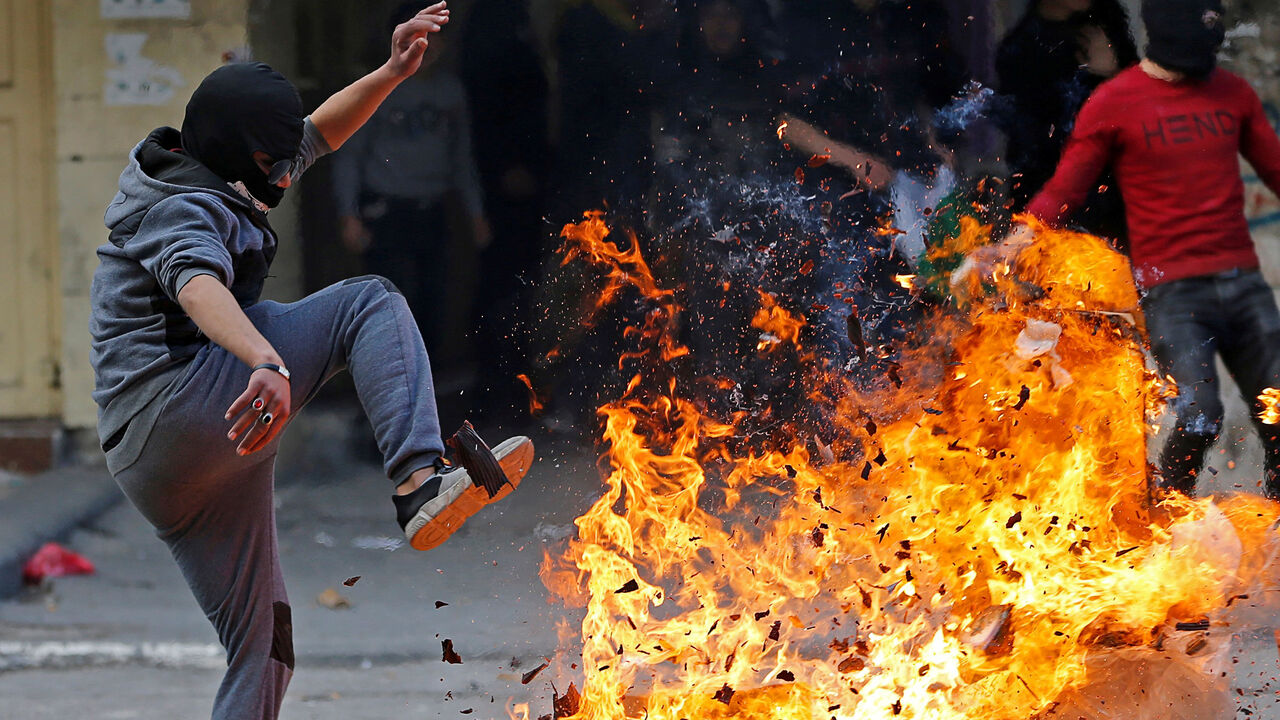 A Palestinian reacts next to a fire during a protest against the U.S. President Donald Trumpís Middle East peace plan, in Hebron in the Israeli-occupied West Bank February 6, 2020. REUTERS/Mussa Qawasma     TPX IMAGES OF THE DAY - RC21VE98476D