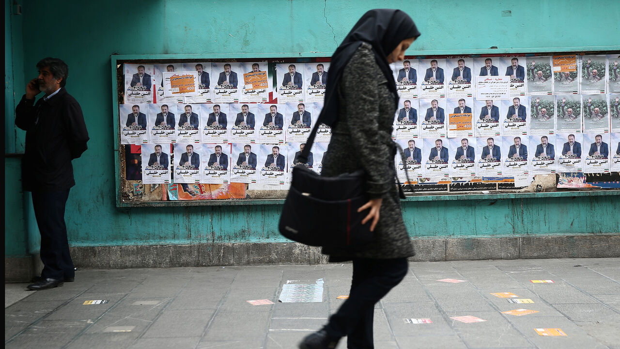 A woman walks past parliamentary election campaign posters in Tehran, Iran February 19, 2020. Picture taken February 19, 2020. WANA (West Asia News Agency)/Nazanin Tabatabaee via REUTERS ATTENTION EDITORS - THIS IMAGE HAS BEEN SUPPLIED BY A THIRD PARTY. - RC2I4F99WETN