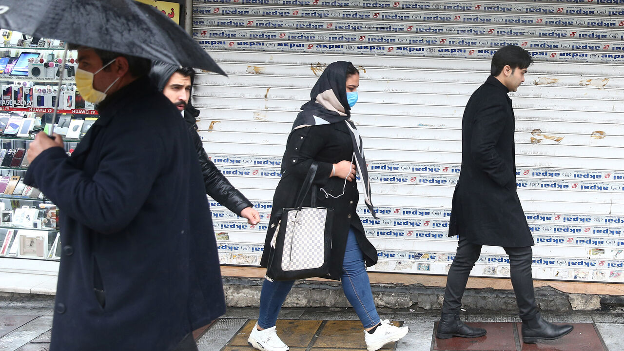 Iranian people wear protective masks to prevent contracting coronavirus, as they walk in the street in Tehran, Iran February 25, 2020. WANA (West Asia News Agency)/Nazanin Tabatabaee via REUTERS ATTENTION EDITORS - THIS IMAGE HAS BEEN SUPPLIED BY A THIRD PARTY. - RC2P7F9O2XY3