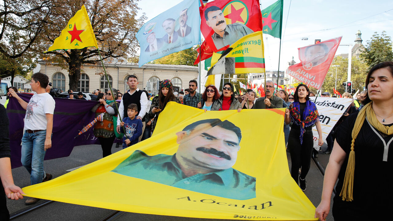 Kurdish protesters carry flags and a banner with a portrait of jailed Kurdistan Workers Party (PKK) leader Abdullah Ocalan during a demonstration against Turkey's military action in northeastern Syria in Zurich, Switzerland October 12, 2019. REUTERS/Arnd Wiegmann - RC148C889EE0