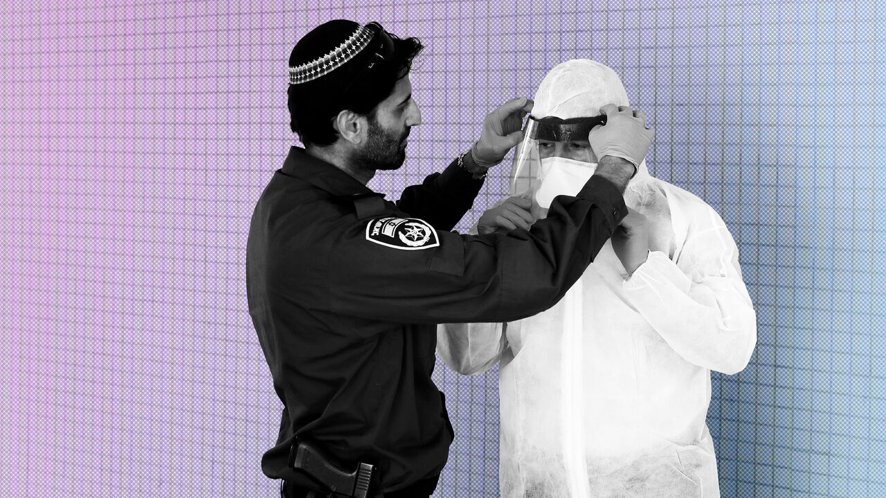 An Israeli police officer helps a Health Ministry inspector put on protective gear before they go up to the apartment of a person in self quarantine as a precaution against coronavirus spread in Hadera, Israel March 16, 2020 REUTERS/Ronen Zvulun - RC23LF9W400M
