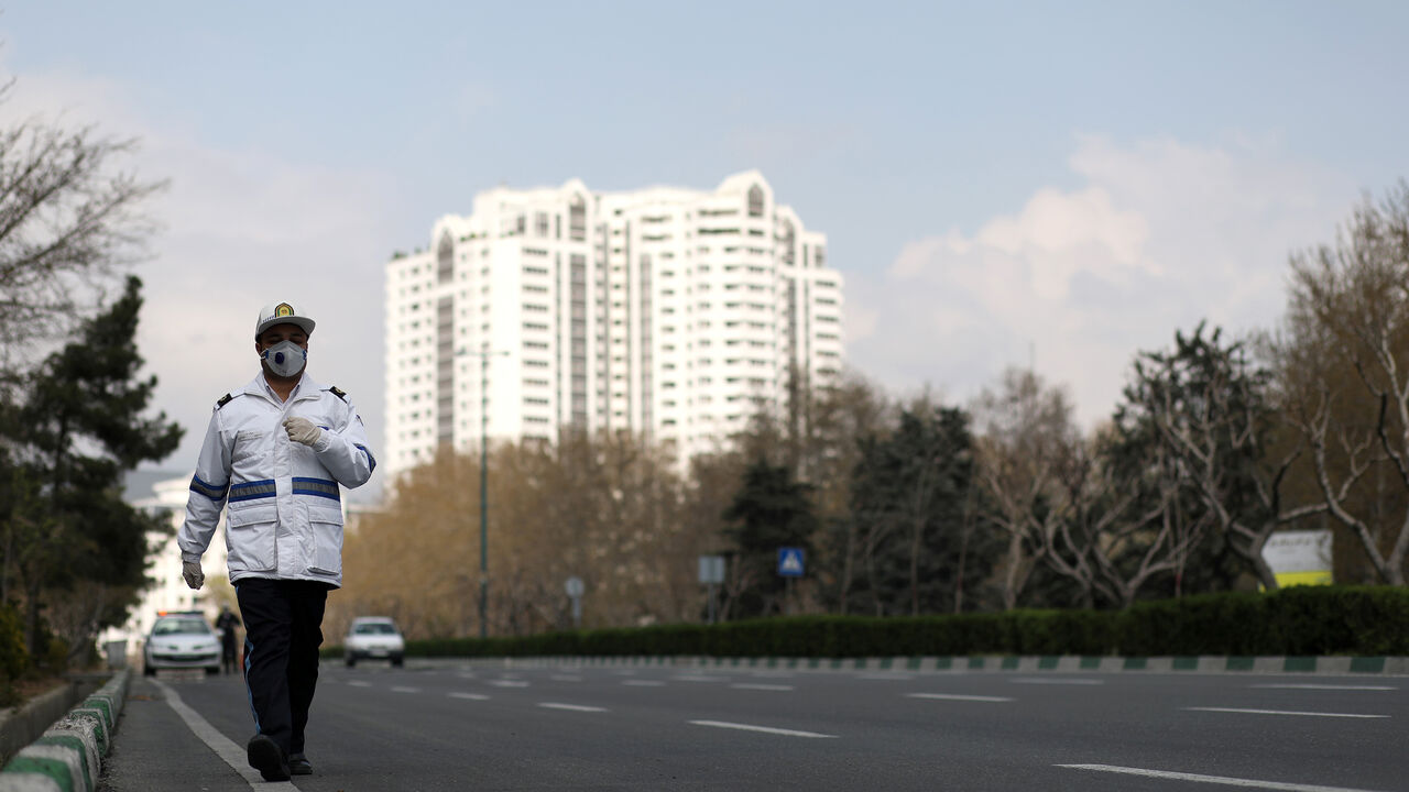 A traffic police officer wears a protective face mask and gloves, amid fear of coronavirus disease (COVID-19), as he walks in Tehran, Iran March 26, 2020. WANA (West Asia News Agency)/Ali Khara via REUTERS ATTENTION EDITORS - THIS PICTURE WAS PROVIDED BY A THIRD PARTY - RC2PRF9GFZAQ