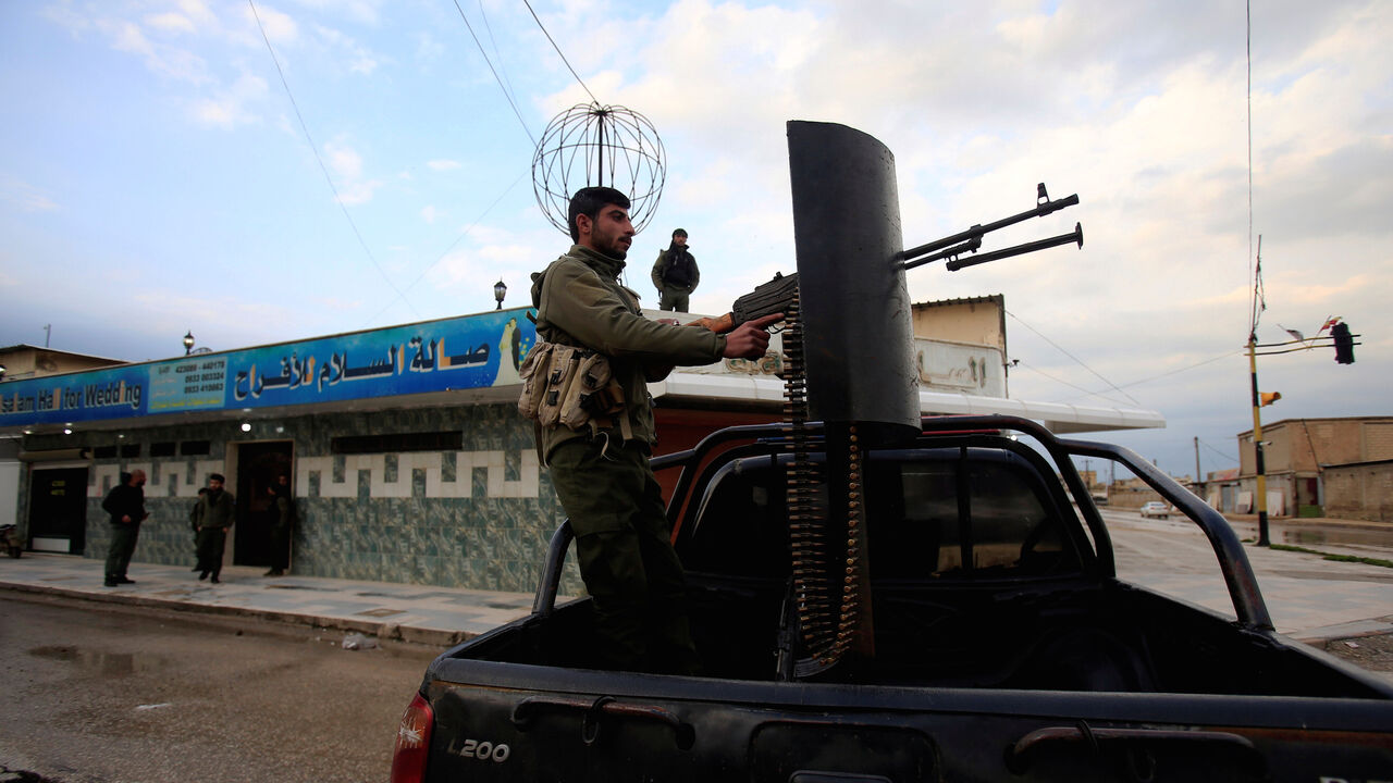 A fighter of Syrian Democratic Forces (SDF) stands on the back of a pick-up truck, with a weapon installed on it, in Qamishli, Syria March 30, 2019. Picture taken March 30, 2019. REUTERS/Ali Hashisho - RC1961AA5550