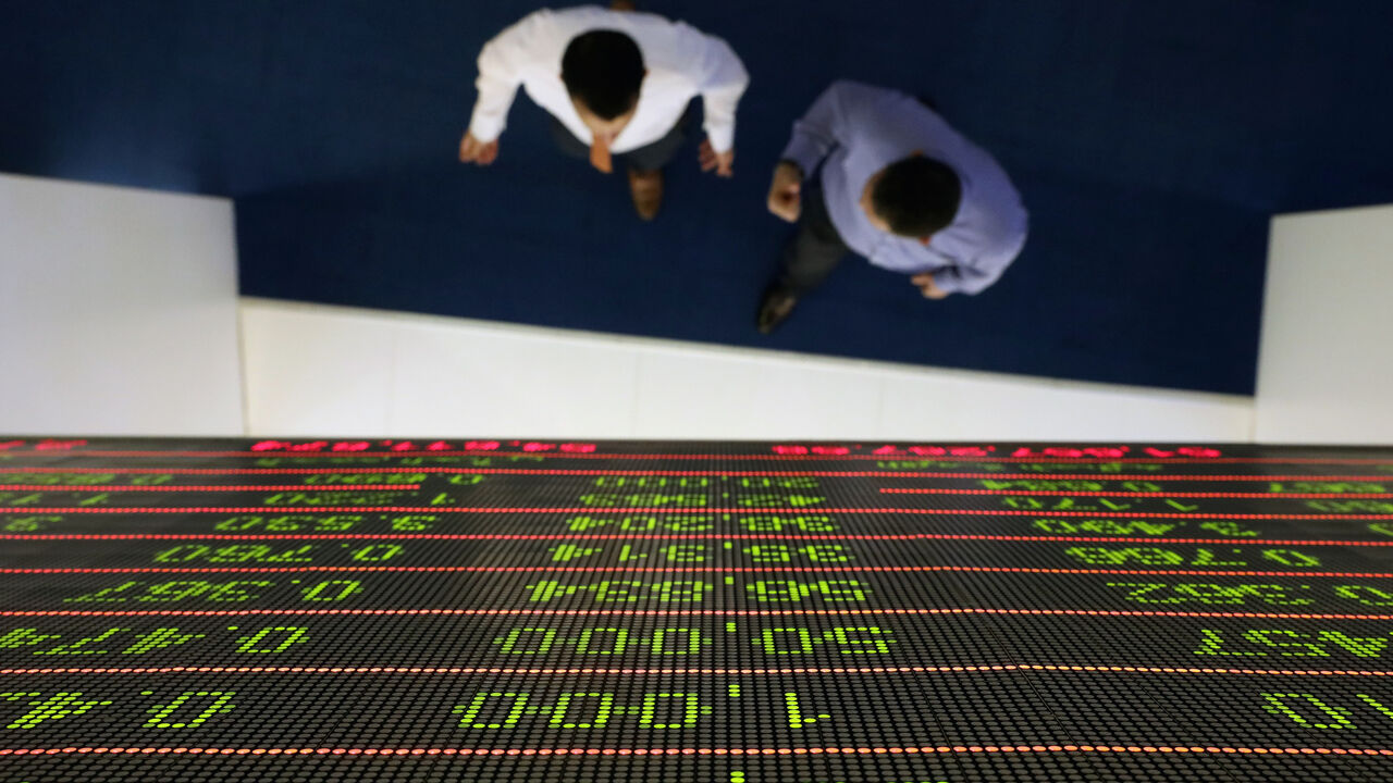 Investors walk under a stock index board at the Dubai Financial Market in Dubai, United Arab Emirates, January 8, 2020. REUTERS/Christopher Pike - RC2NBE9J9TZ4