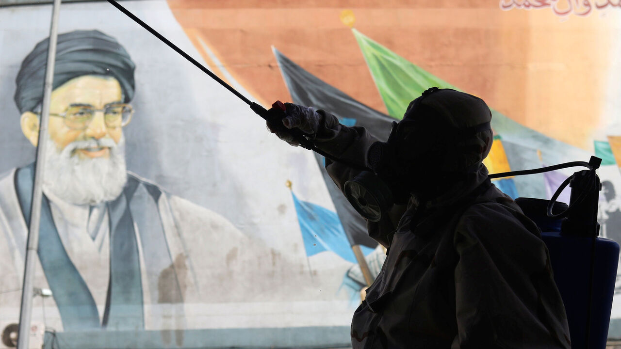 A volunteer from Basij forces wearing a protective suit and face mask sprays disinfectant as he sanitizes a bus station, amid the coronavirus disease (COVID-19) fears, in Tehran, Iran April 3, 2020. WANA (West Asia News Agency)/Ali Khara via REUTERS ATTENTION EDITORS - THIS PICTURE WAS PROVIDED BY A THIRD PARTY - RC2YWF9PA44V
