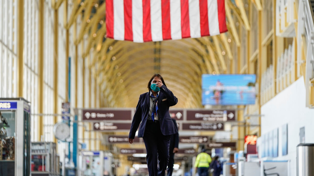 An airline employee walks through Reagan National Airport during the coronavirus disease (COVID-19) outbreak in Washington, U.S., April 5, 2020.      REUTERS/Joshua Roberts - RC2KYF955PLJ