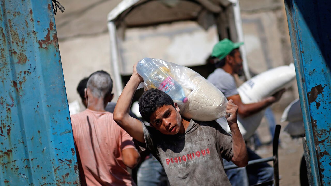 A Palestinian carries food supplies at an aid distribution center run by the United Nations Relief and Works Agency (UNRWA), in Al-Shati refugee camp in Gaza City September 25, 2019. REUTERS/Mohammed Salem - RC16E05A7E10