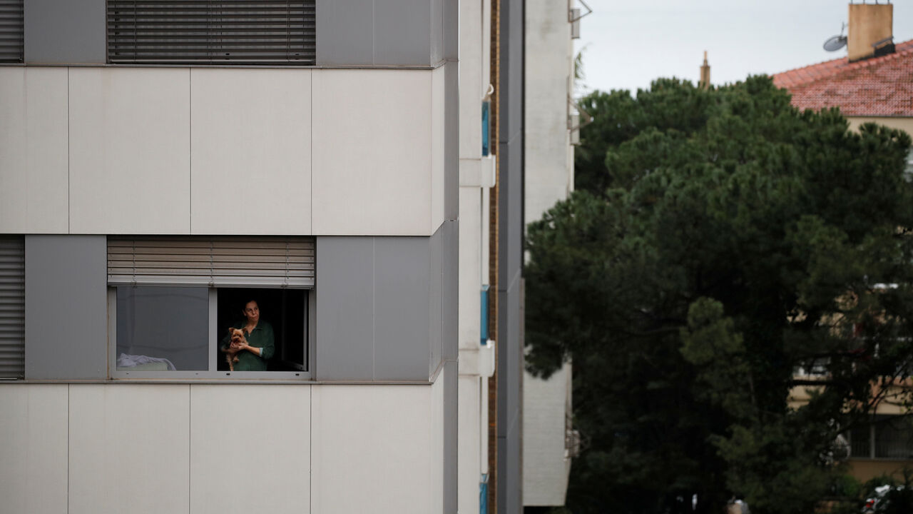 A woman and her dog look out from the window of their home as the spread of the coronavirus disease (COVID-19) continues in Istanbul, Turkey, April 15, 2020. REUTERS/Umit Bektas - RC235G9RI3TN