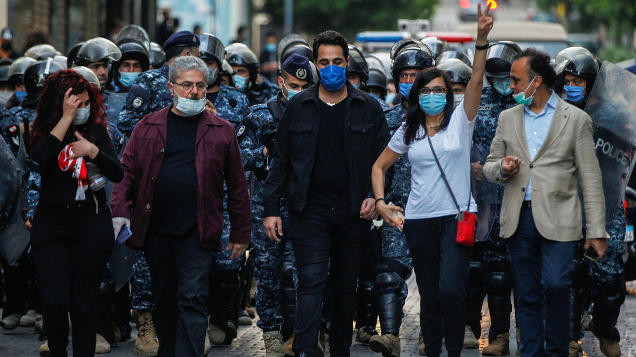 Lebanese demonstrators wear face masks during a protest against the collapsing Lebanese pound currency outside Lebanon's Central Bank in Beirut, Lebanon April 23, 2020. REUTERS/Mohamed Azakir - RC2IAG903BZB