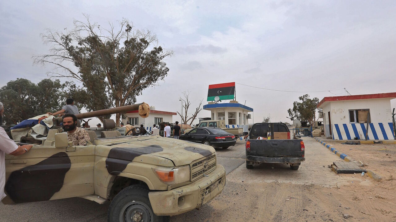 Vehicles of forces loyal to Libya's UN-recognised Government of National Accord (GNA) are seen outside a checkpoint at Al-Watiya airbase also known as Okba Ibn Nafa airbase, which they seized control of, southwest of the capital Tripoli, on May 18, 2020. - Libya's UN-recognised government scored another battlefield victory Monday against strongman Khalifa Haftar, capturing the key rear base used by his fighters in a conflict now in its second year. Haftar, who controls swathes of eastern Libya, launched an 
