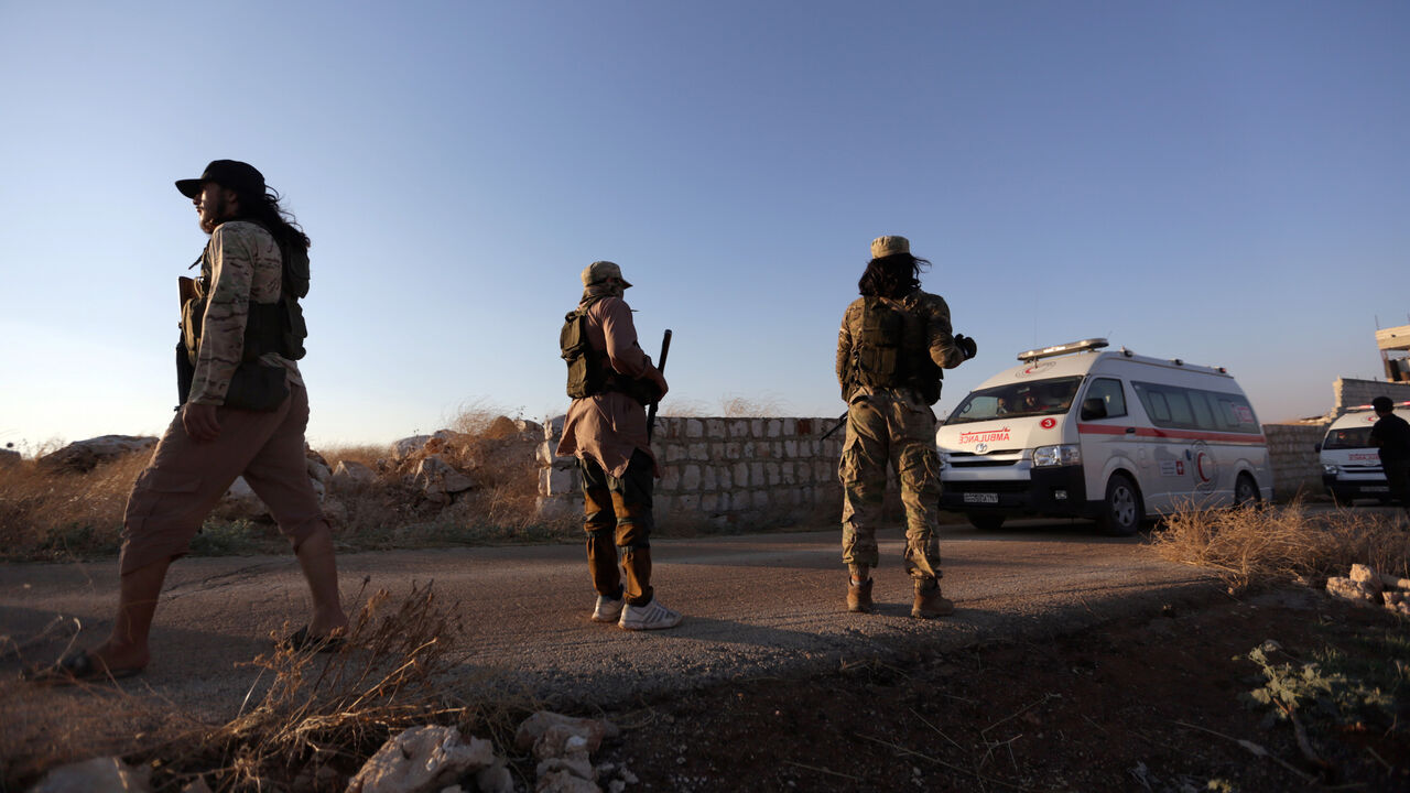 An ambulance passes by Islamist rebels from Hayat Tahrir al-Sham outside the villages of al-Foua and Kefraya,Syria July 18, 2018. REUTERS/Khalil Ashawi - RC1BD239EA00