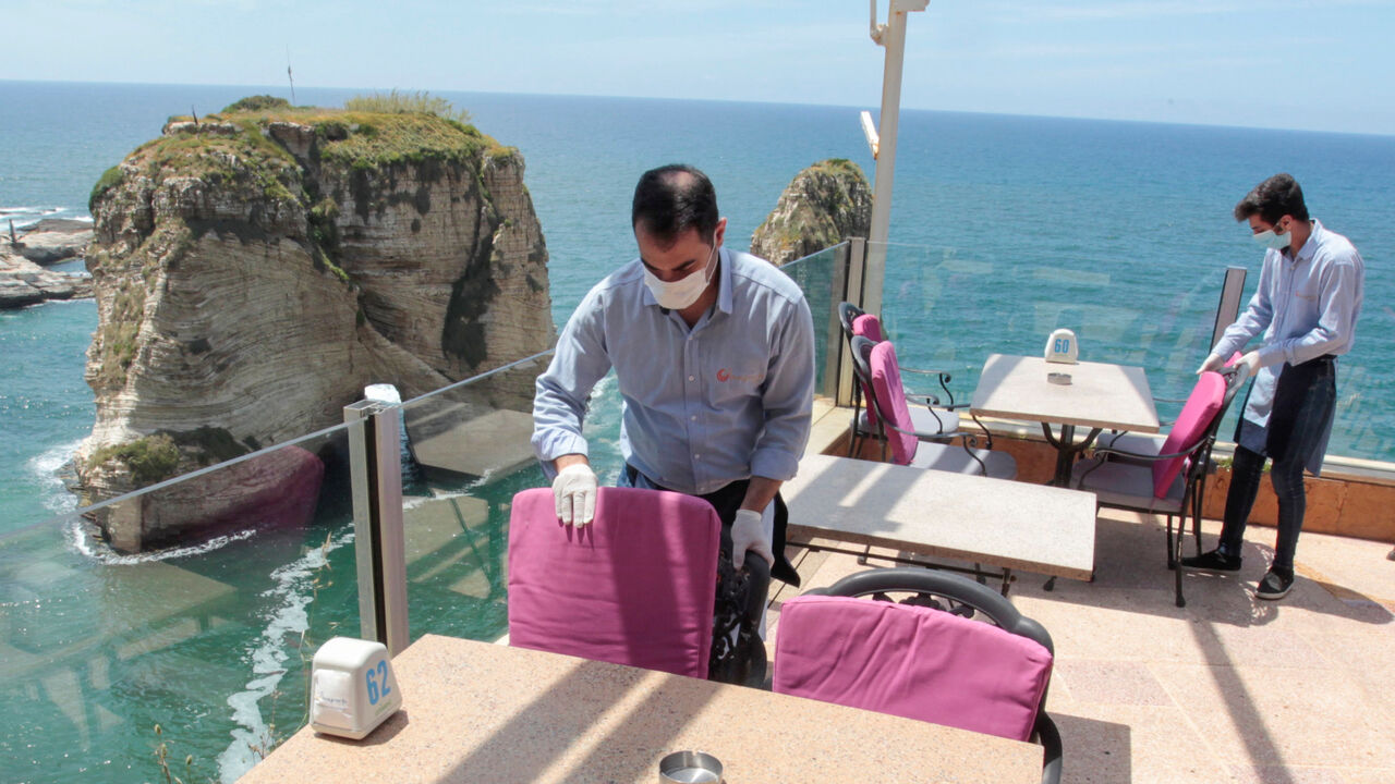 Waiters fix chairs at a restaurant overlooking the Pigeons Rock, as Lebanon begins to ease nationwide lockdown due to spread of the coronavirus disease (COVID-19) in Beirut, Lebanon May 4, 2020. REUTERS/Aziz Taher - RC2PHG9CXB7K