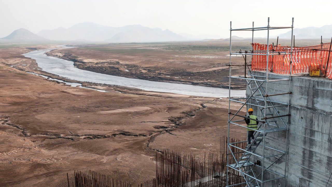 A worker goes down a construction ladder at the Grand Ethiopian Renaissance Dam (GERD),   near Guba in Ethiopia, on December 26, 2019. - The Grand Ethiopian Renaissance Dam, a 145-metre-high, 1.8-kilometre-long concrete colossus is set to become the largest hydropower plant in Africa.
Across Ethiopia, poor farmers and rich businessmen alike eagerly await the more than 6,000 megawatts of electricity officials say it will ultimately provide. 
Yet as thousands of workers toil day and night to finish the projec