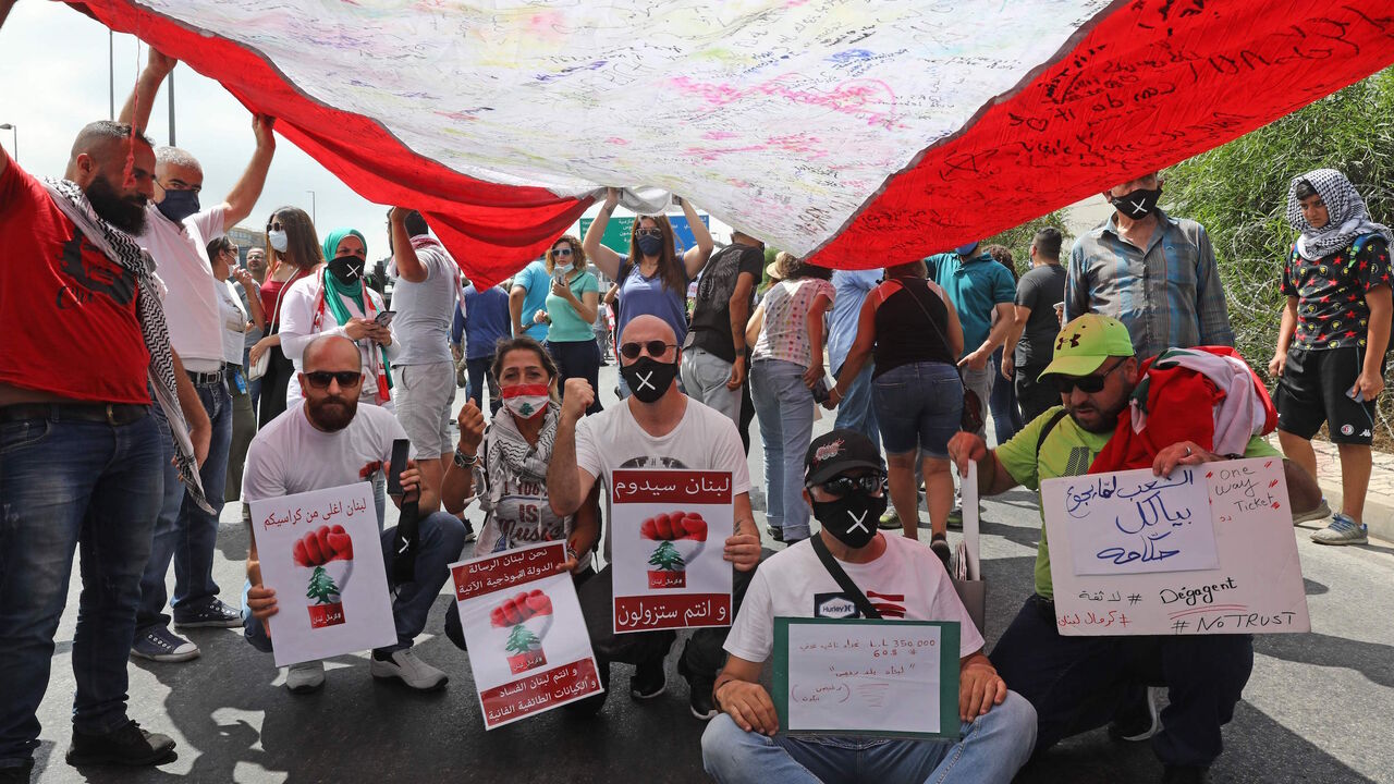 Lebanese anti-government protesters carry a large national flag during a demonstration near the presidential palace in Baabda, east of Beirut, on June 25, 2020. (Photo by ANWAR AMRO / AFP) (Photo by ANWAR AMRO/AFP via Getty Images)