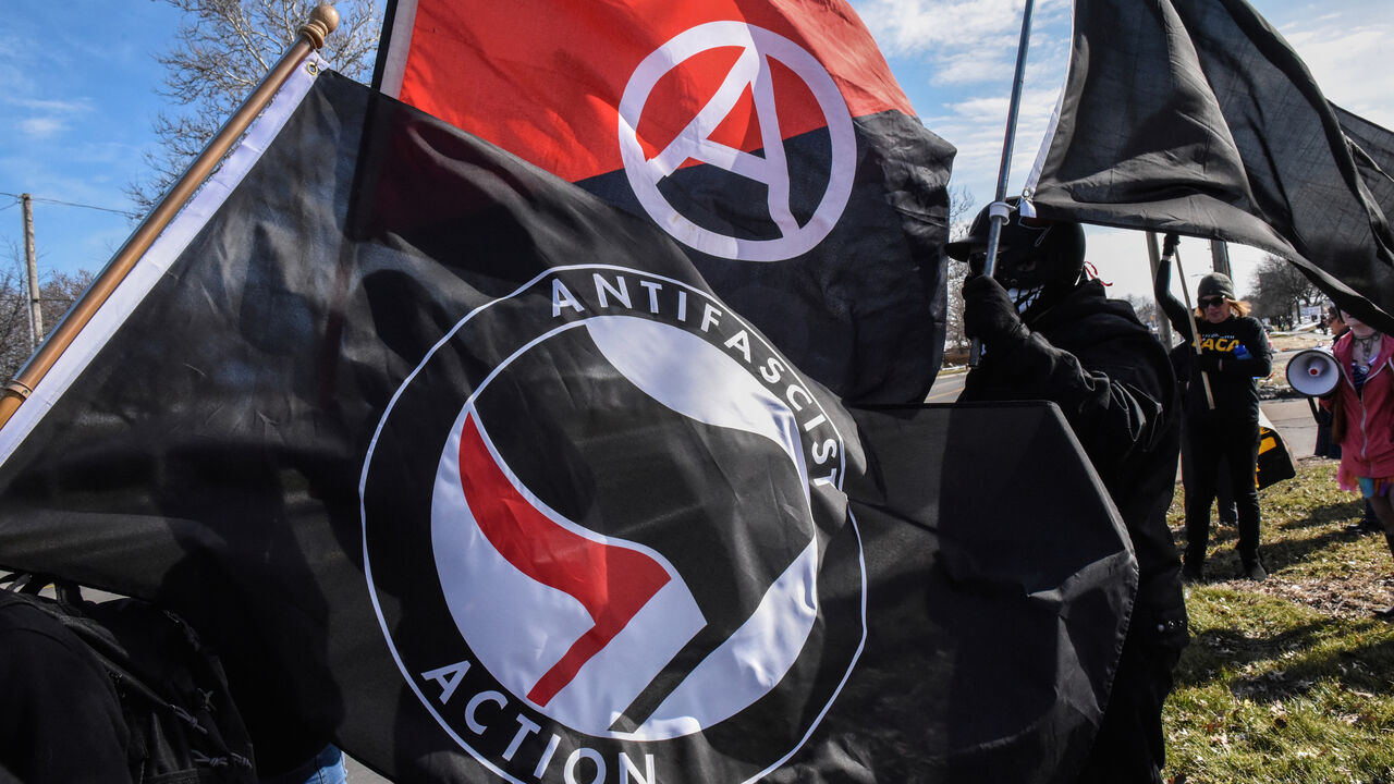 Members of the Great Lakes anti-fascist organization (Antifa) fly flags during a protest against the Alt-right outside a hotel in Warren, Michigan, U.S., March 4, 2018. REUTERS/Stephanie Keith - RC1B5E31E310