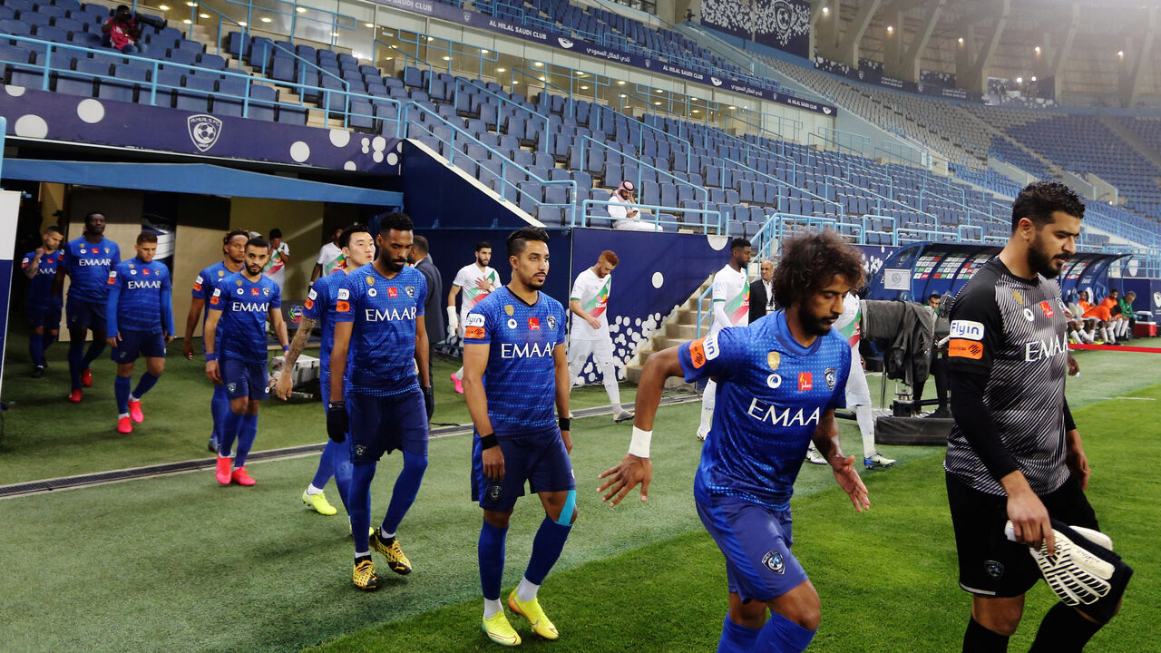 Football players enter the pitch as the stands are seen empty after the decision of the Saudi Ministry of Sports, following an outbreak of the coronavirus disease (COVID-19), during the Saudi Professional League soccer match between AL-Hilal and Al-Ettifaq at King Saud University Stadium, in Riyadh, Saudi Arabia March 7, 2020. Picture taken March 7, 2020. REUTERS/Ahmed Yosri - RC2MFF9J8T68