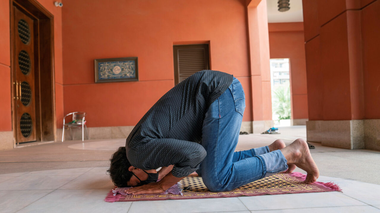 A man wearing a protective face mask prays on the first day of the holy month of Ramadan in the hallway of a mosque closed due to the outbreak of the coronavirus disease (COVID-19), in Kuwait City, Kuwait April 24, 2020. REUTERS/Stephanie McGehee - RC2ZAG9SCZVI