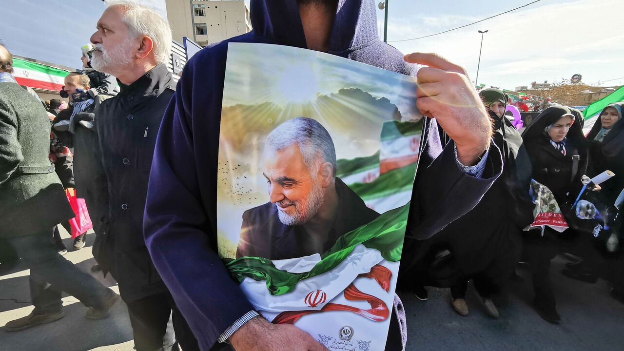 A Iranian man carries a portrait of slain Iranian General Qasem Soleimani, on the 40th day of his killing in a US drone strike, during commemorations marking 41 years since the Islamic Revolution, in the capital Tehran on February 11, 2020. - Thousands of Iranians massed for commemorations marking 41 years since the Islamic Revolution, in a show of unity at a time of heightened tensions with the United States. The celebrations mark the day that Shiite cleric Khomeini returned from exile and ousted the shah'
