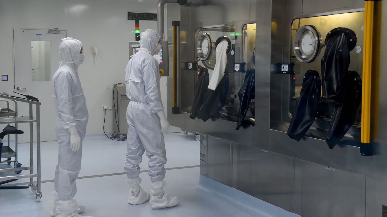 Employees wearing protective equipment work at the production line of Russia's biotech company BIOCAD, which is developing its own vaccine against the new coronavirus and working on another one in cooperation with the country's virus research centre in Siberia, Vektor, in Strelna on May 20, 2020. (Photo by OLGA MALTSEVA / AFP) (Photo by OLGA MALTSEVA/AFP via Getty Images)