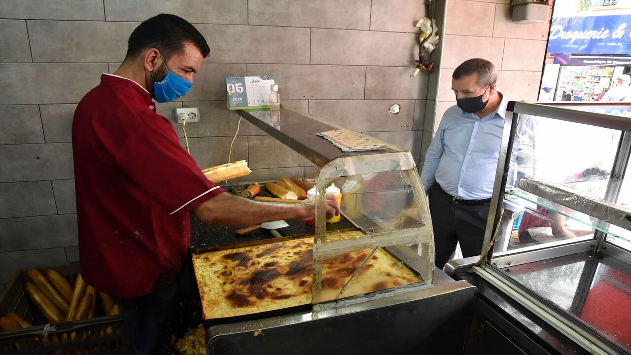 An Algerian man buys a sandwich at a shop in the capital Algiers on June 7, 2020, after authorities eased some restrictions put in place in a bid to fight the spread of the novel coronavirus. (Photo by RYAD KRAMDI / AFP) (Photo by RYAD KRAMDI/AFP via Getty Images)